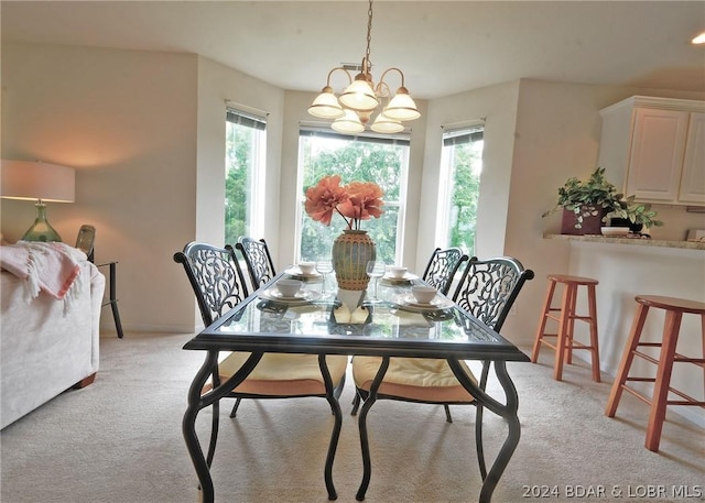 dining space featuring light colored carpet, an inviting chandelier, and plenty of natural light