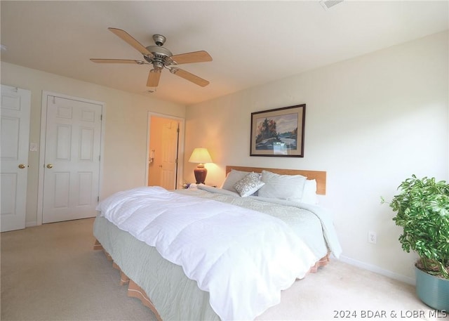 carpeted bedroom featuring baseboards and a ceiling fan