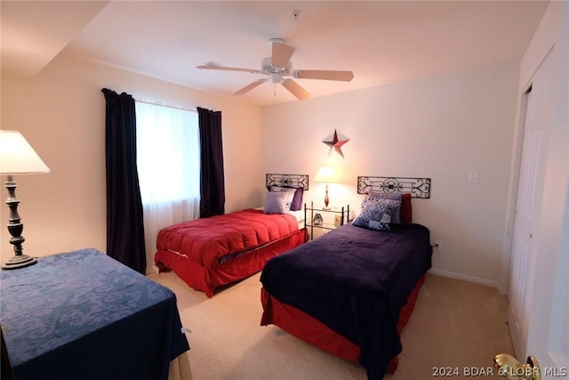bedroom with a ceiling fan, baseboards, carpet, and a closet