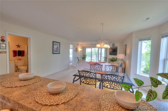 dining area with visible vents, plenty of natural light, and an inviting chandelier