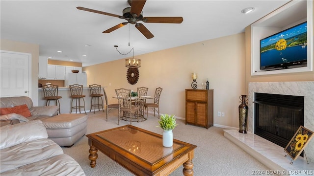 living room featuring ceiling fan, light carpet, and a fireplace