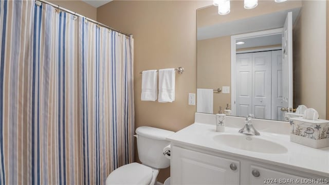 bathroom with a shower with shower curtain, vanity, and toilet