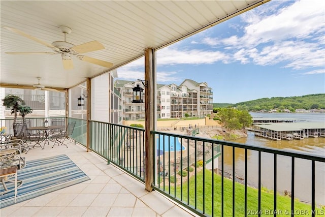 balcony with ceiling fan and a water view