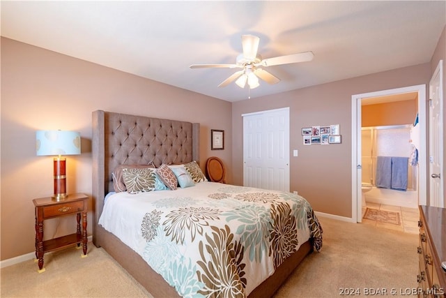 bedroom featuring ensuite bath, ceiling fan, a closet, and light colored carpet