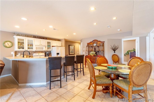 dining space with light tile patterned floors and sink