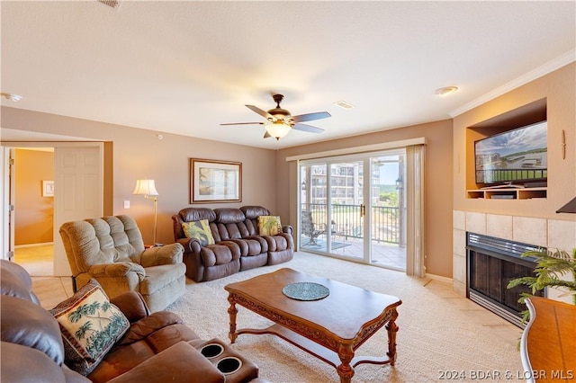 living room featuring a tile fireplace, light colored carpet, and ceiling fan