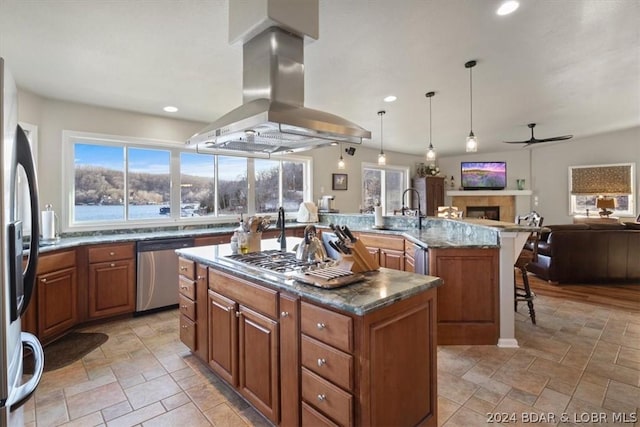 kitchen with island range hood, stainless steel appliances, pendant lighting, a spacious island, and sink