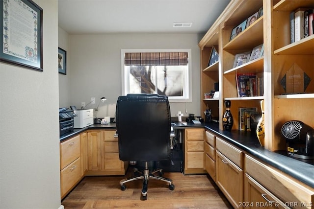 home office featuring built in desk and light wood-type flooring