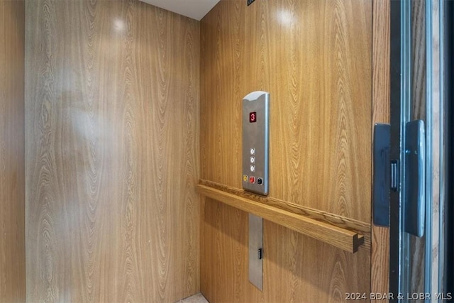 room details featuring elevator and wooden walls