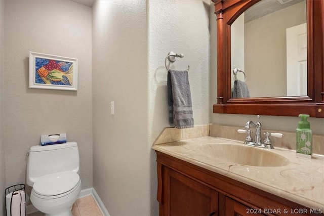 bathroom with toilet, tile patterned flooring, and vanity