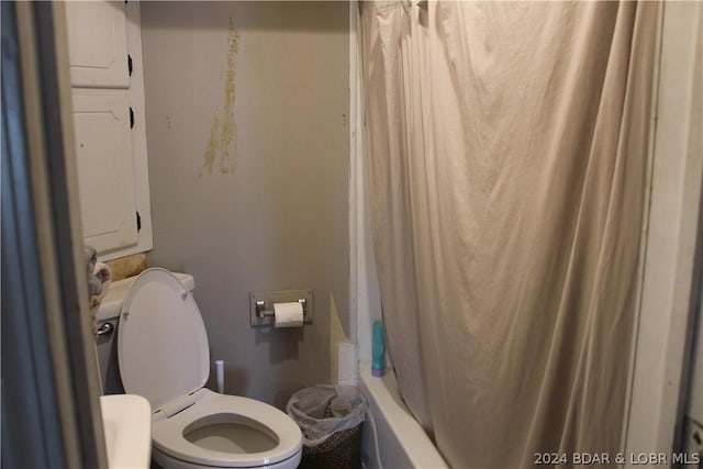 bathroom featuring shower / tub combo with curtain and toilet