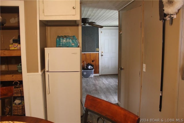 kitchen featuring white refrigerator, ceiling fan, wood-type flooring, and white cabinets