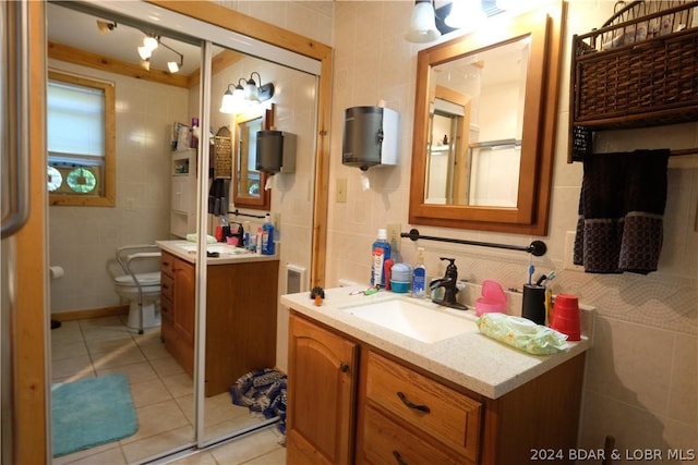 bathroom featuring vanity, tile walls, tile patterned floors, and toilet