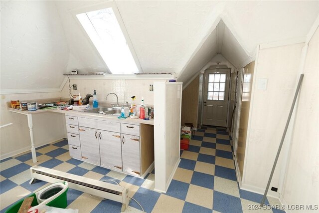 kitchen with lofted ceiling with skylight and sink