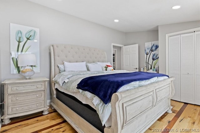 bedroom featuring vaulted ceiling, light hardwood / wood-style flooring, and a closet