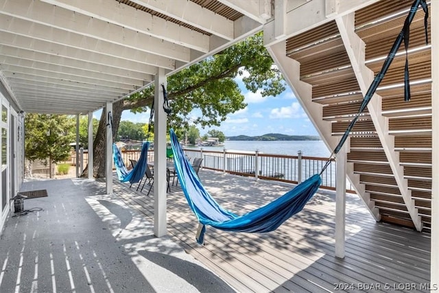 deck with a playground and a water view