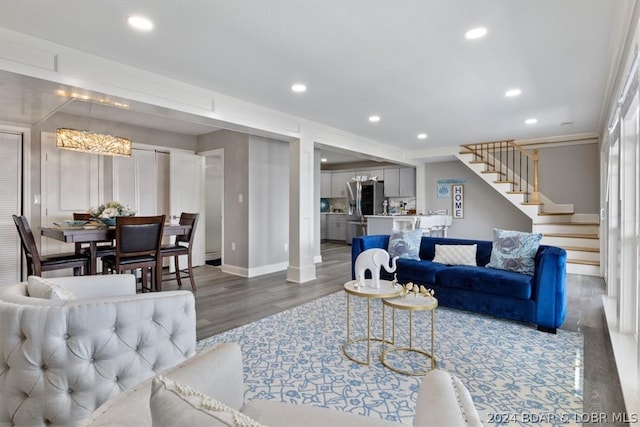 living room with dark hardwood / wood-style flooring and a notable chandelier