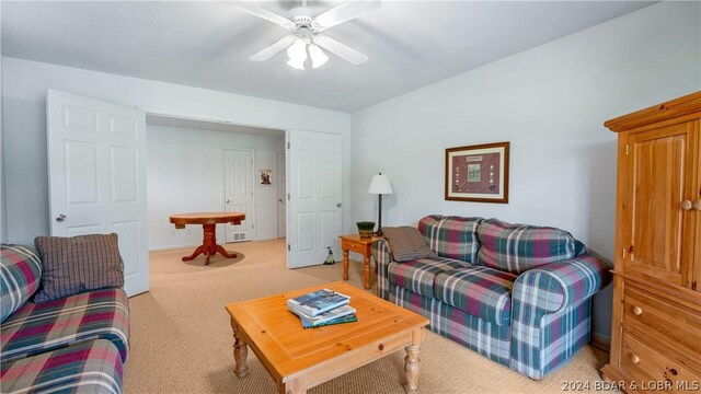 living room featuring ceiling fan and light carpet