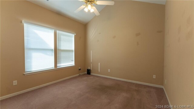 unfurnished room with lofted ceiling, ceiling fan, light carpet, and plenty of natural light