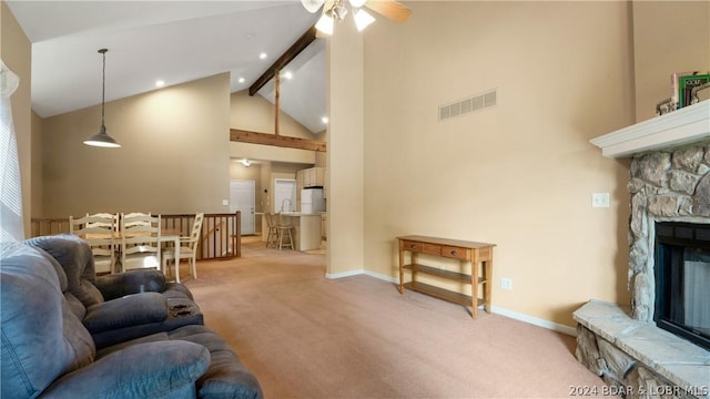 living room with light carpet, beamed ceiling, ceiling fan, high vaulted ceiling, and a fireplace