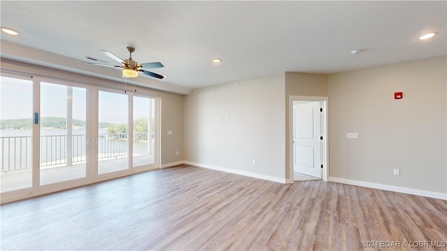 spare room with light hardwood / wood-style floors and ceiling fan