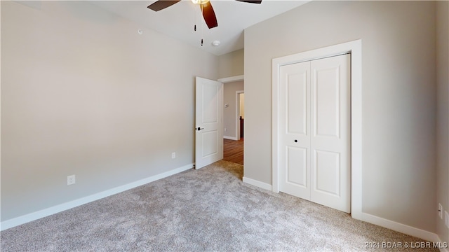 unfurnished bedroom with light carpet, ceiling fan, and a closet