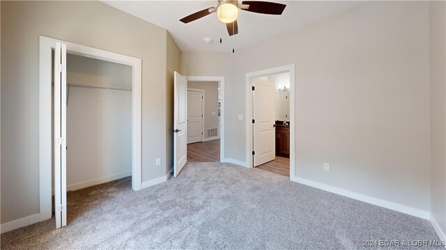 unfurnished bedroom with light carpet, a closet, and ceiling fan