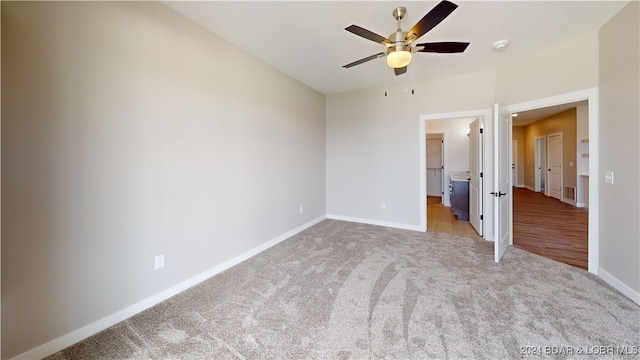 unfurnished bedroom with ceiling fan and light colored carpet