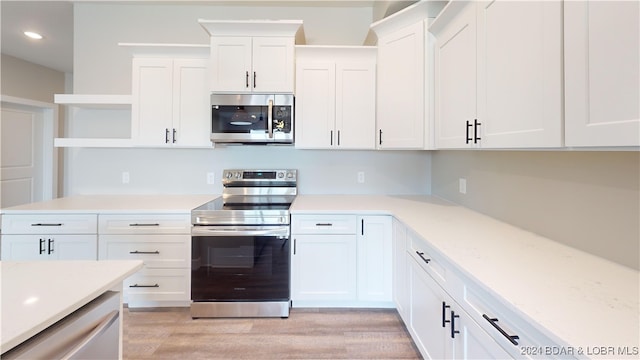 kitchen featuring light stone counters, white cabinets, and appliances with stainless steel finishes