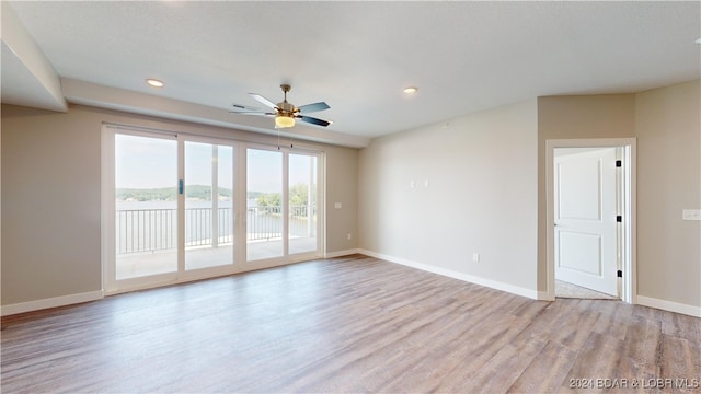 empty room featuring ceiling fan and light hardwood / wood-style flooring