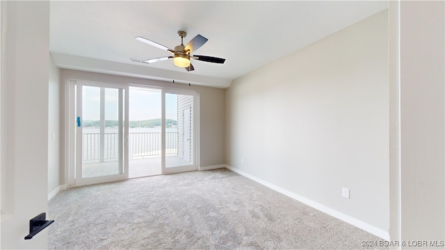 carpeted spare room featuring ceiling fan