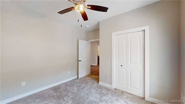 unfurnished bedroom with light carpet, a closet, and ceiling fan