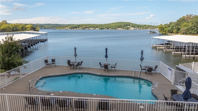 view of swimming pool with a patio and a water view