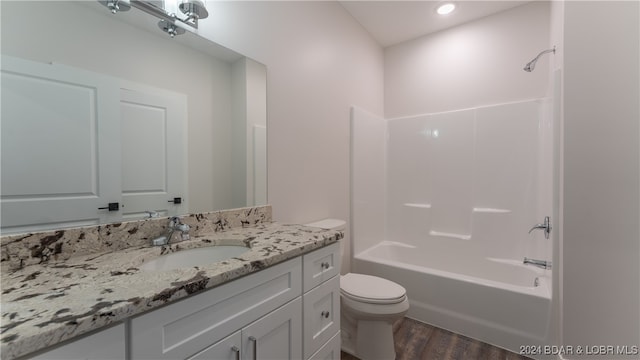 full bathroom with wood-type flooring, shower / bathtub combination, vanity, and toilet