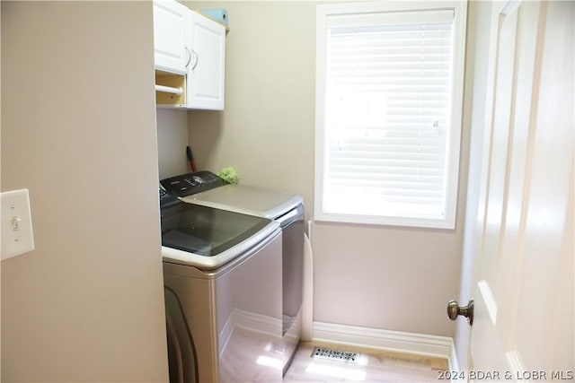 laundry area featuring washer and dryer and cabinets