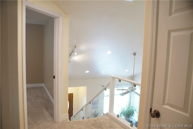 staircase featuring carpet floors, track lighting, and ceiling fan