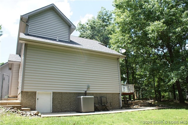 view of home's exterior featuring a shingled roof and cooling unit