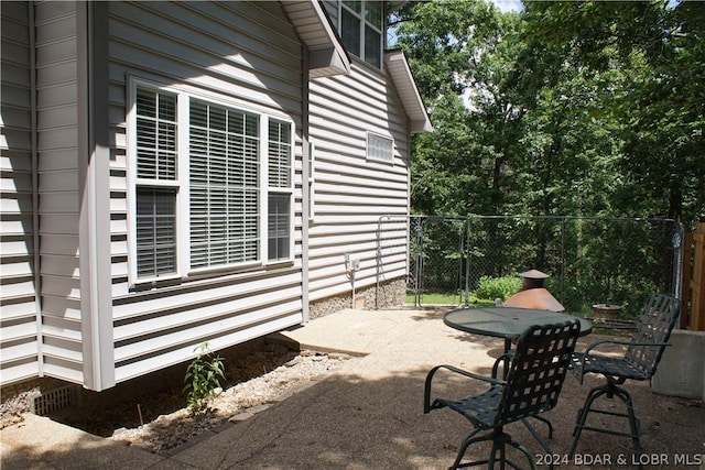 view of side of property featuring a patio and fence