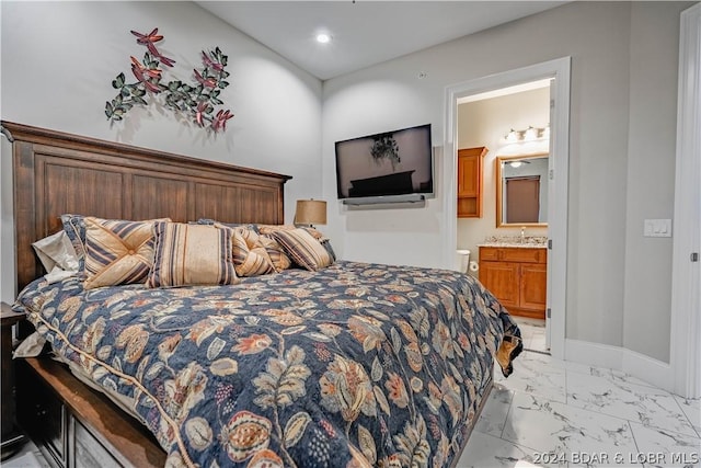 bedroom featuring connected bathroom and sink