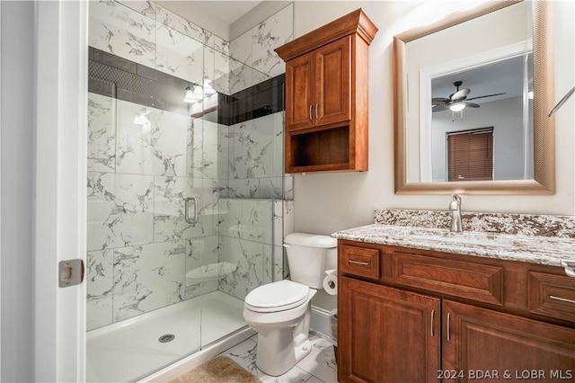 bathroom with ceiling fan, toilet, a shower with shower door, and vanity