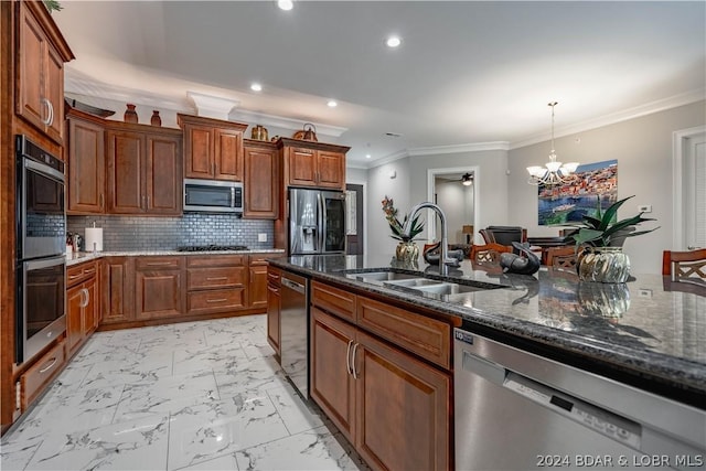 kitchen with decorative backsplash, appliances with stainless steel finishes, sink, dark stone countertops, and hanging light fixtures