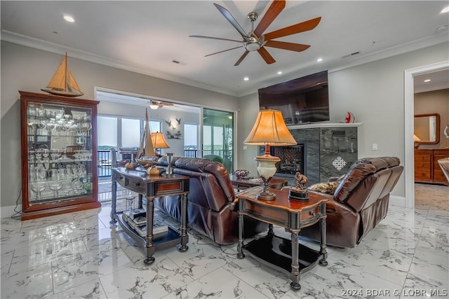 living room with ceiling fan, a fireplace, and ornamental molding