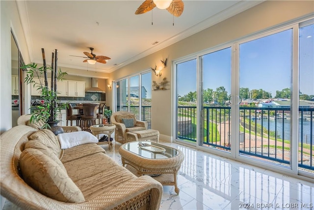 sunroom with ceiling fan and a water view