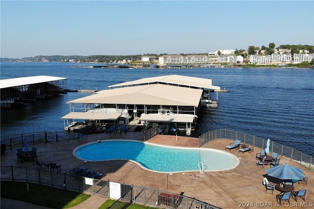 view of pool featuring a water view and a patio area