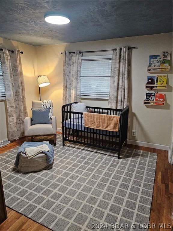 bedroom with a textured ceiling and hardwood / wood-style floors