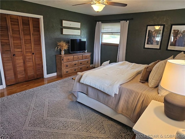 bedroom with hardwood / wood-style flooring, ceiling fan, and a closet