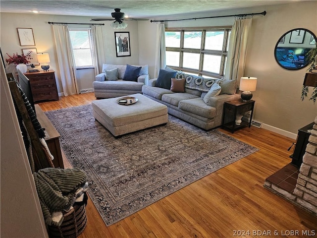 living room featuring a fireplace, ceiling fan, and hardwood / wood-style floors