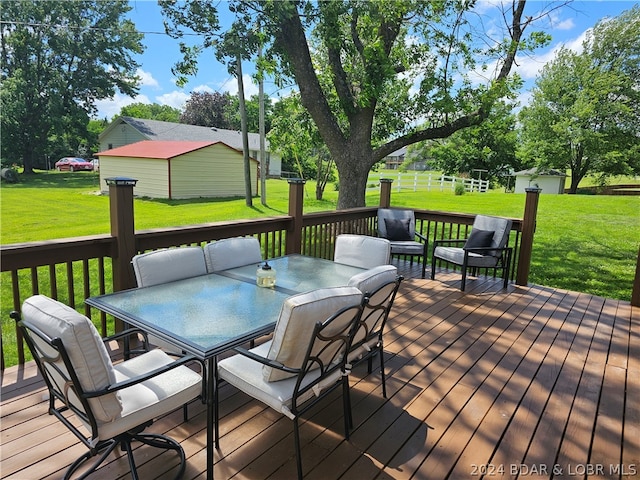 deck with a yard and an outdoor structure