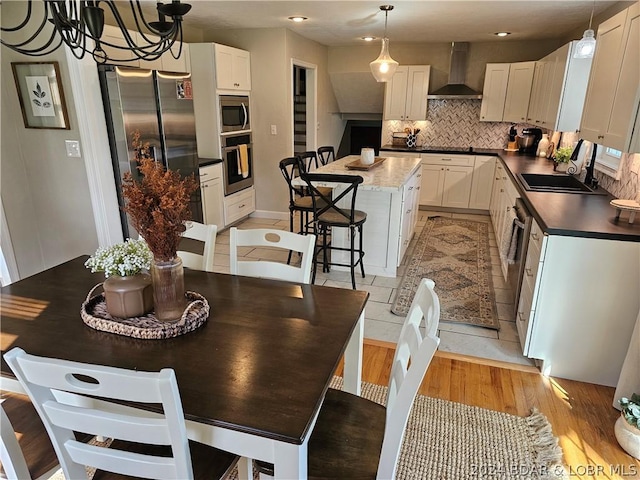 dining room featuring sink, light hardwood / wood-style floors, and a notable chandelier