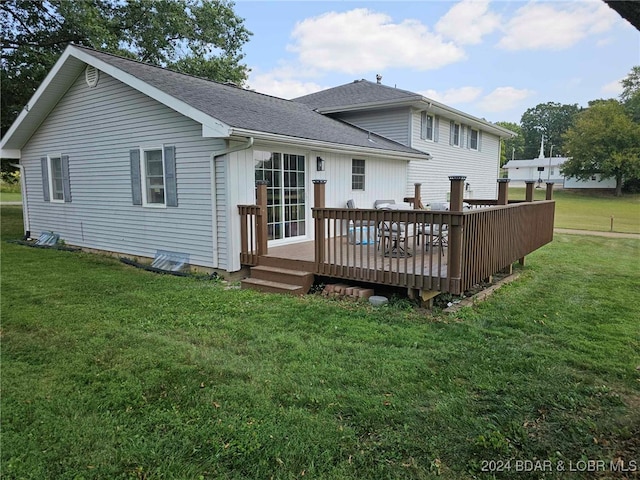 back of property with a wooden deck and a lawn